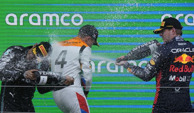 Winner Red Bull driver Max Verstappen of the Netherlands. right, sprays champagne on second placed McLaren driver Lando Norris of Britain, and third Mercedes driver Lewis Hamilton of Britain, left, after the British Formula One Grand Prix race at the Silverstone racetrack, Silverstone, England, Sunday, July 9, 2023. (AP Photo/Luca Bruno)