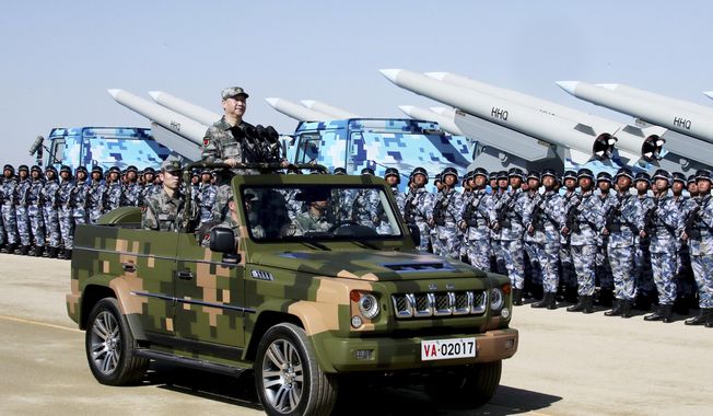 In this photo released by Xinhua News Agency, Chinese President Xi Jinping stands on a military jeep as he inspects troops of the People&#x27;s Liberation Army during a military parade to commemorate the 90th anniversary of the founding of the PLA at Zhurihe training base in north China&#x27;s Inner Mongolia Autonomous Region, Sunday, July 30, 2017. Xi was dubbed &amp;quot;chairman of everything&amp;quot; after he put himself in charge of economic, propaganda and other major functions. That reversed a consensus for the ruling inner circle to avoid power struggles by sharing decision-making. (Li Tao/Xinhua via AP, File)