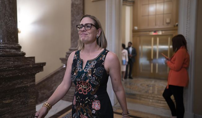 Sen. Kyrsten Sinema, I-Ariz., shuttles between the chamber and the whip office as the Senate dashes to wrap up votes on amendments on the big debt ceiling and budget cuts package, at the Capitol in Washington, Thursday, June 1, 2023. (AP Photo/J. Scott Applewhite)