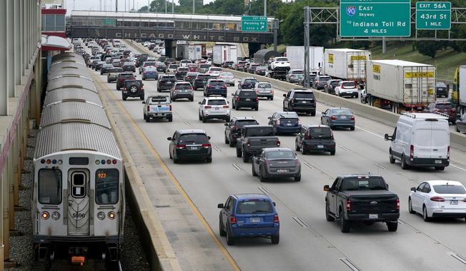 Motorists head southbound in the local and express lanes on Interstates 90-94 in slow and thickening traffic as a CTA train enters a station on the first day of the Fourth of July holiday weekend Friday, July 1, 2022, in Chicago. (AP Photo/Charles Rex Arbogast)