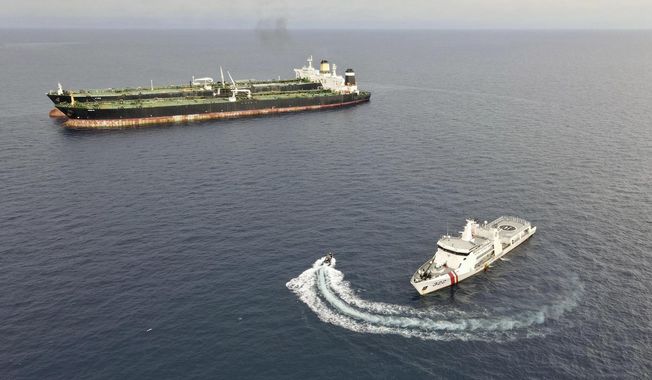 In this undated photo released Tuesday, July 11, 2023, by Indonesian Maritime Security Agency (BAKAMLA), a BAKAMLA patrol ship inspects the Iranian-flagged, MT Arman 114 and Cameroon-flagged tanker, MT S Tinos after they are caught conducting illegal oil transfer near Natuna waters, Indonesia. Indonesian authorities said Wednesday, July 12, 2023, that they have seized an Iranian tanker and arrested its crew members for illegally transferring oil to another vessel in the country’s exclusive economic zone. (BAKAMLA via AP)
