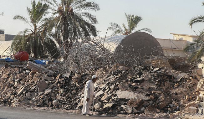 A man walks past the rubble of a demolished al-Siraji Mosque in Basra, Iraq, on Monday, July 17, 2023. An official said the old mosque would be replaced with a modern, better-designed one that would not impede traffic flow. (AP Photo/Nabil al-Jurani)