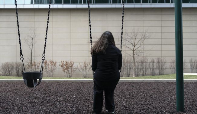 Amelia, 16, sits for a portrait in a park near her home in Illinois on Friday, March 24, 2023. (AP Photo Erin Hooley)