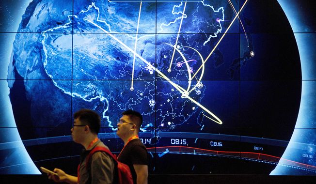 Attendees walk past an electronic display showing recent cyberattacks in China at the China Internet Security Conference in Beijing, on Sept. 12, 2017. Hackers linked to China were likely behind the exploitation of a software security hole in cybersecurity firm Barracuda Networks’ email security feature that affected public and private organizations globally, according to an investigation by security firm Mandiant. (AP Photo/Mark Schiefelbein, File)